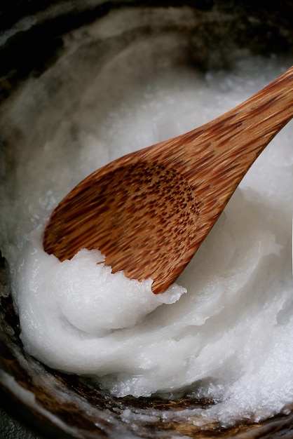 Huile de noix de coco biologique dans un bol de noix de coco sur une cuillère de noix de coco. Concept de durabilité. Fermer.