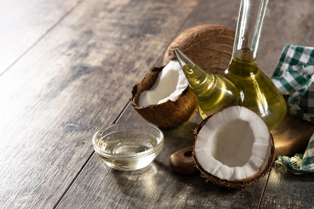 Photo huile de noix de coco en bouteille de cristal sur table en bois