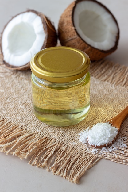 Photo huile de noix de coco dans un bocal et noix de coco fraîches. cosmétiques naturels.