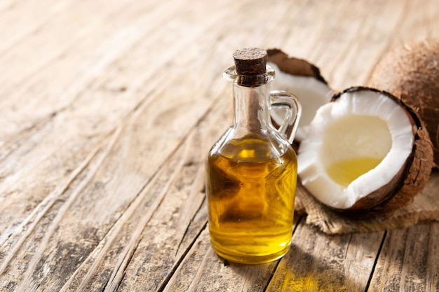 Huile de noix de coco et huile de bouteille sur table en bois