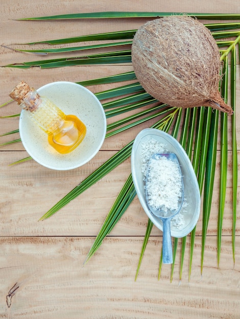 Huile de noix de coco et de noix de coco en poudre sur fond en bois.