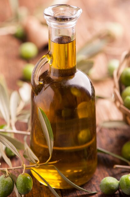 Huile d'olive et olives sur table rustique en bois