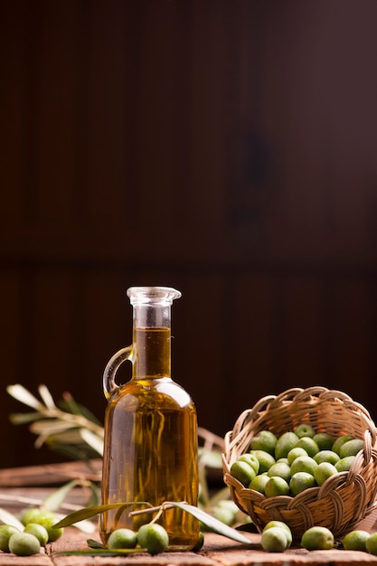 Huile d'olive et olives sur table rustique en bois