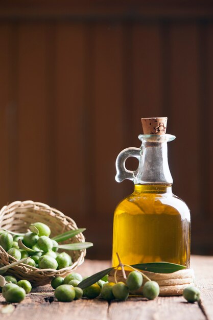 Huile d'olive et olives sur table rustique en bois
