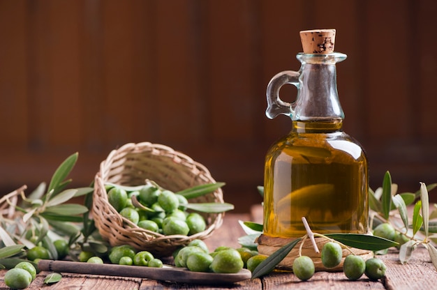 Huile d'olive et olives sur table rustique en bois