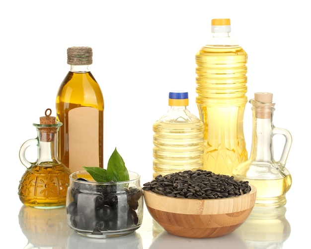 Photo huile d'olive et de tournesol dans les bouteilles et petites carafes sur blanc