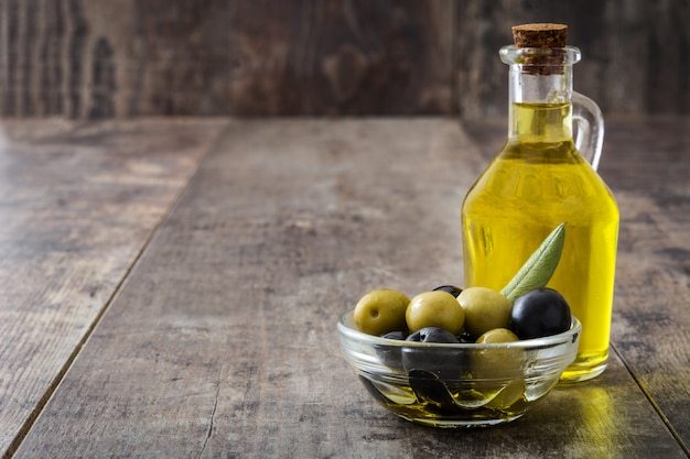 Huile d'olive vierge dans une bouteille en cristal sur table en bois