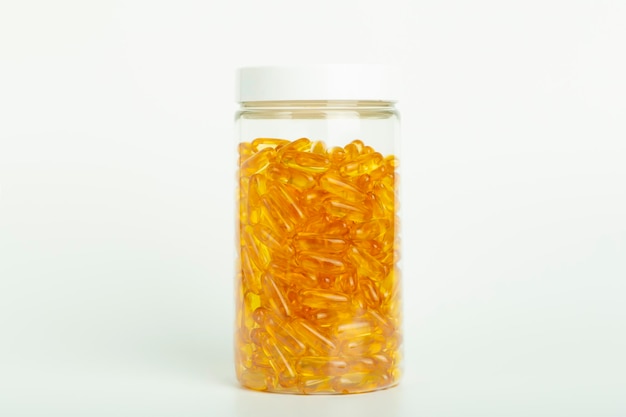 L'huile de poisson dans des capsules de gélatine isole les vitamines oméga dans des pilules de couleur dorée sur un blanc