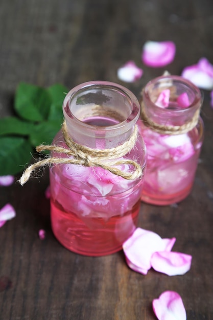 Huile de rose en bouteilles sur fond de bois de couleur