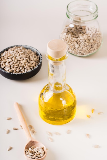 Huile de tournesol dans une bouteille et graines de tournesol dans un bol sur la table Alimentation saine Vue verticale