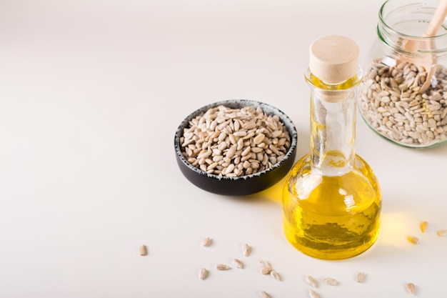 Huile de tournesol dans une bouteille et graines de tournesol dans un bol sur la table Alimentation saine