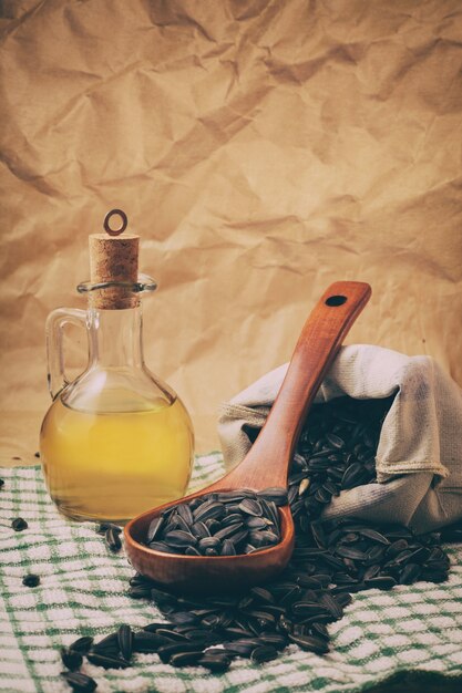 Huile de tournesol avec un sac de graines et une cuillère en bois