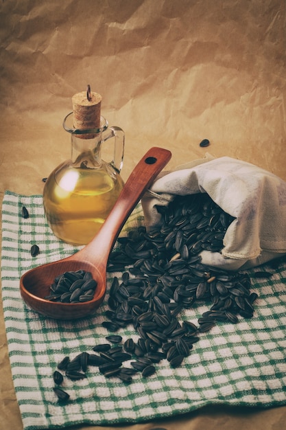 Huile de tournesol avec un sac de graines et une cuillère en bois