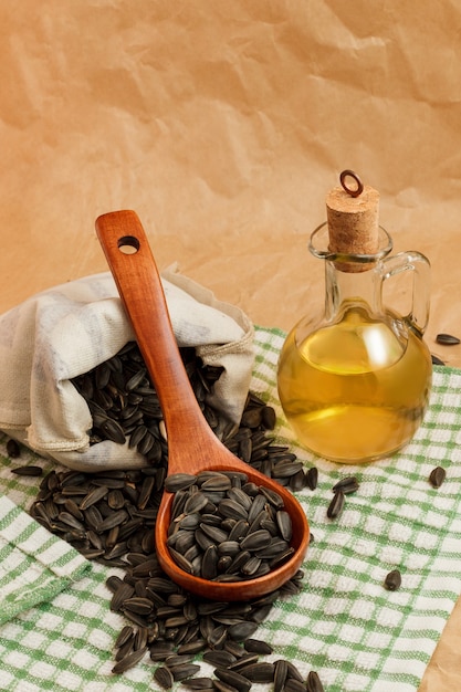 Huile de tournesol avec un sac de graines et une cuillère en bois