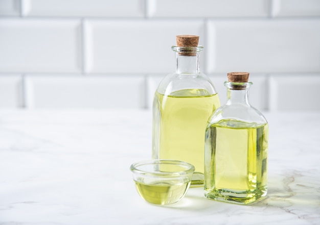 Photo huile végétale naturelle dans une bouteille transparente sur la table de la cuisine. alimentation saine diététique. vue de face et espace de copie