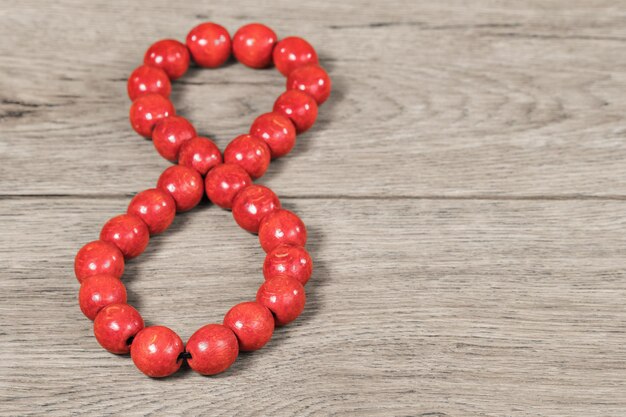 Huit chiffres bordés de perles en bois rouge sur une vieille table en bois