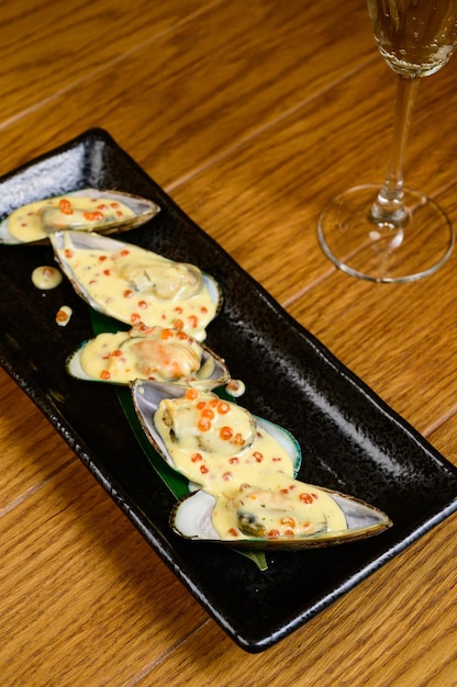 Huîtres au caviar rouge sur fond en bois.Huîtres ouvertes au caviar rouge.Vue de dessus, pose à plat, espace de copie.