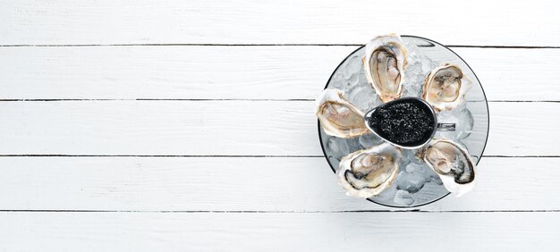 Huîtres et caviar noir dans une assiette de glace et de citron Fruits de mer Vue de dessus Espace de copie gratuit