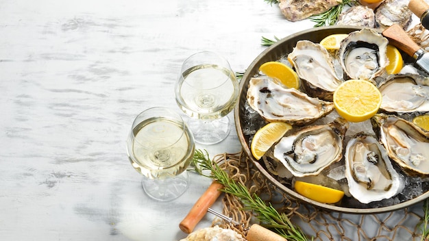 Huîtres fraîches ouvertes et vin blanc et citron. Espace libre pour votre texte. Fruits de mer. Mise à plat.