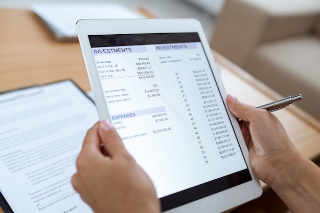 Human hands holding touchpad avec document électronique contenant des informations financières