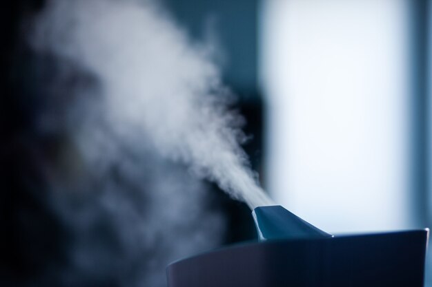 Humidificateur diffusant de la vapeur dans une pièce sombre