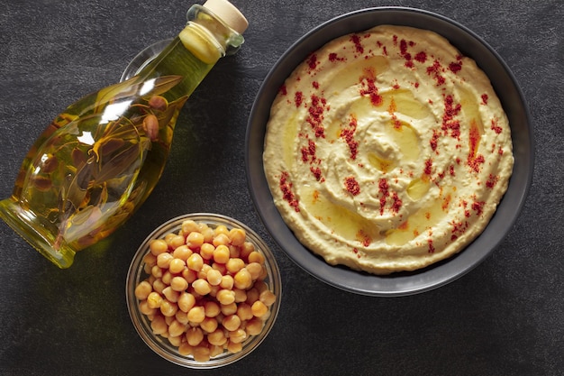 Hummus avec de l'huile dans une bouteille et des épices dans un bol vue du haut