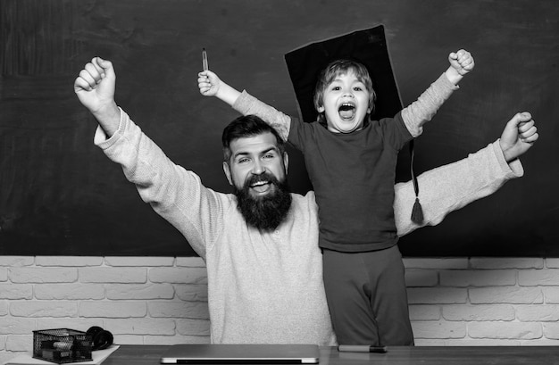 Photo hurra papa et fils levant les poings serrés dans le geste hurra père enseignant son fils en classe