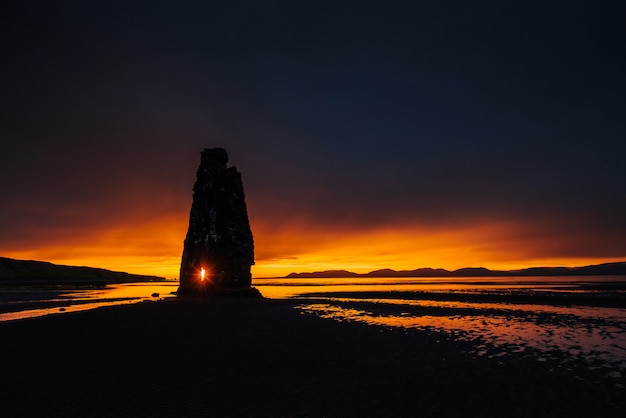 Hvitserkur 15 m de hauteur. Est un rocher spectaculaire dans la mer sur la côte nord de l'Islande. cette photo se reflète dans l'eau après le coucher du soleil de minuit.
