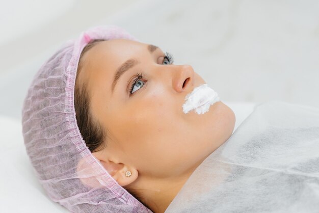 Hydrater les lèvres lors d'une procédure cosmétique pour une jeune fille. Cosmétologie.