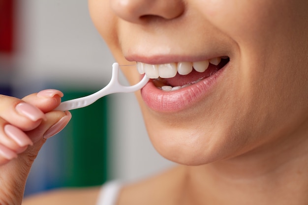 Photo hygiène bucco-dentaire et soins de santé, les femmes souriantes utilisent des dents saines blanches de soie dentaire.