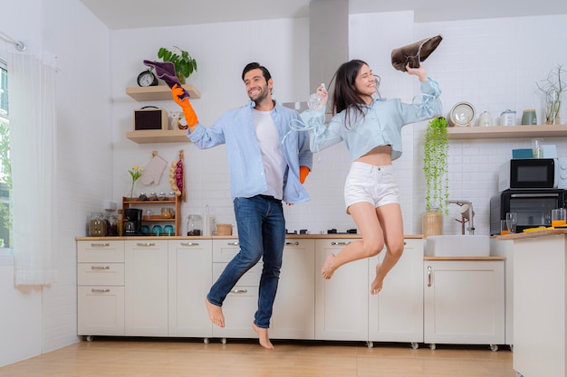 Hygiène des tâches ménagères pendant le temps libre Jeune couple de famille faisant le ménage dans la maison Concept de nettoyage Enthousiaste jeune femme européenne et homme faisant la vaisselle