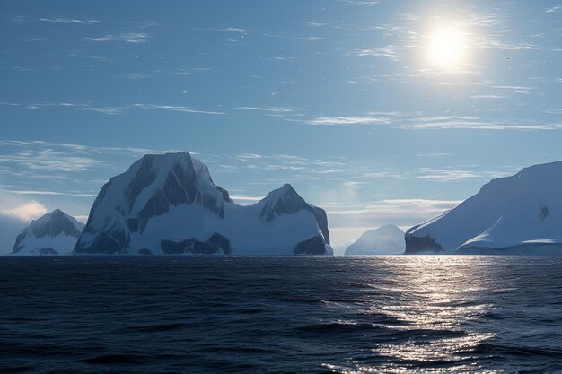 Photo des icebergs bleus, des montagnes et le soleil polaire se reflétant dans le lagon de la mer à la croisière en antarctique dans le détroit de l'empire.