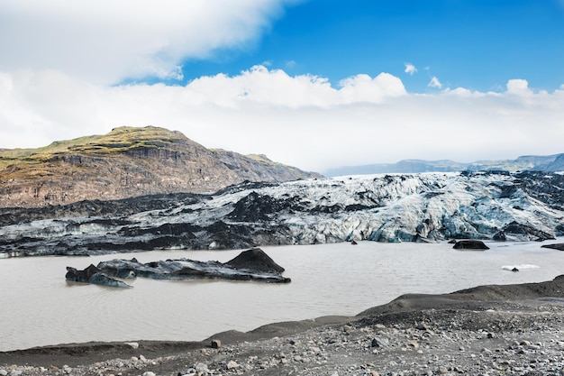 Icebergs avec des cendres volcaniques noires dans la lagune glaciaire, Islande.