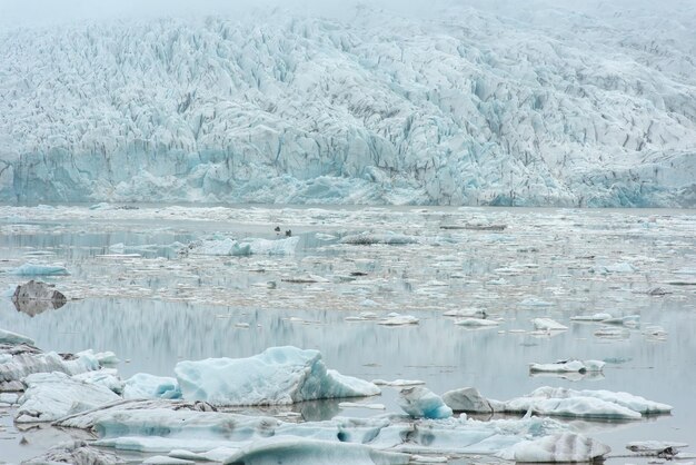 Photo des icebergs flottants à la dérive dans l'eau dans le lagon glaciaire de fjallsarlon parc national de vatnajokull islande concept de réchauffement climatique