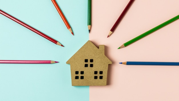 Icône de maison en bois brun sur fond bleu et rose