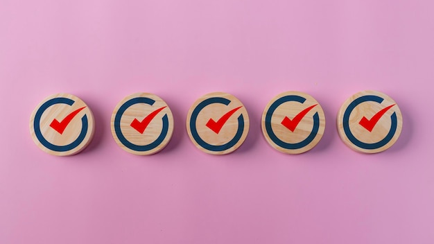 Icône de marque de contrôle sur des blocs de bois Listes de contrôle Apps de rappel Listes de tâches Enquêtes évaluation de formulaires en ligne Réalisation d'objectifs et succès commercial Réalisation des objectifs de l'entreprise et succès commercial