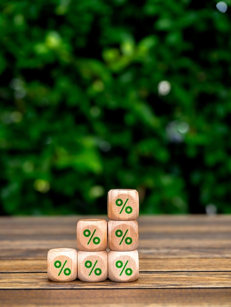 Photo icône de pourcentage vert sur des blocs de cube en bois construire comme des étapes de graphique d'affaires sur une table en bois sur fond d'arbre avec un espace de copie vertical concepts de processus de croissance commerciale et de durabilité environnementale