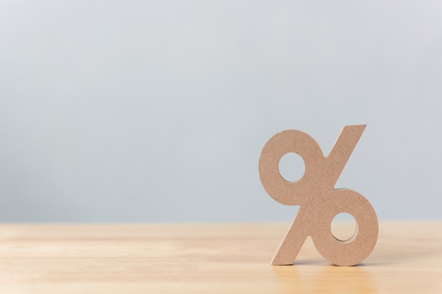 Icône de symbole de signe en pourcentage en bois sur une table en bois avec un fond blanc