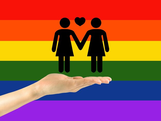 Icônes de deux lesbiennes avec coeur à portée de main sur fond arc-en-ciel