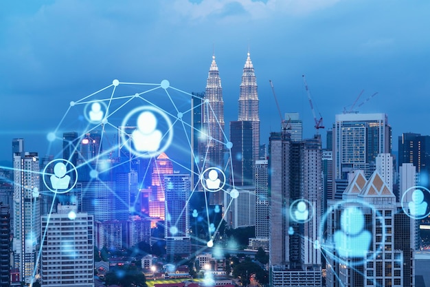 Icônes lumineuses des médias sociaux sur la vue panoramique nocturne de la ville de Kuala Lumpur Malaisie Asie Le concept de mise en réseau et d'établissement de nouvelles connexions entre les personnes dans les entreprises de KL Double exposition