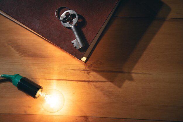 Idée concept, clé avec ampoule et livre sur table