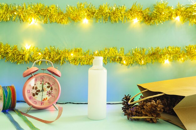 Idée de concept minimaliste affichant des produits. bouteilles cosmétiques sur fond de noël et du nouvel an. réveil. fleur de pin