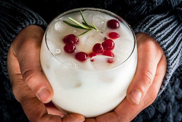 Idées De Boissons Pour Noël Et Action De Grâces. Mains Féminines Avec Punch De Noël Blanc Margarita Aux Canneberges Et Au Romarin, Confortable, Vue Rapprochée,