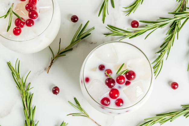 Idées de boissons pour Noël et action de grâces. Punch margarita de Noël blanc aux canneberges et romarin, sur une table en marbre blanc, vue du dessus