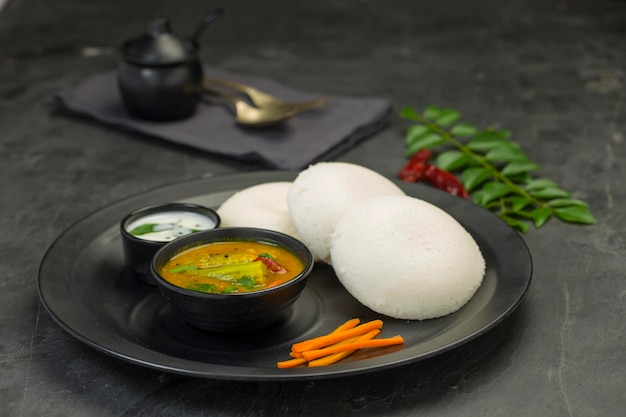 Idly ou Idli, élément principal du petit-déjeuner du sud de l'Inde, magnifiquement disposé dans une assiette noire