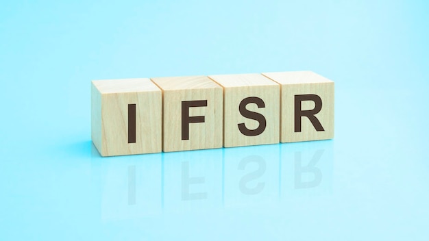 Ifsr une abréviation de blocs de bois avec des lettres Reflet de la légende sur la surface en miroir de la table Mise au point sélective ifsr court pour la notation de la solidité financière de l'assurance