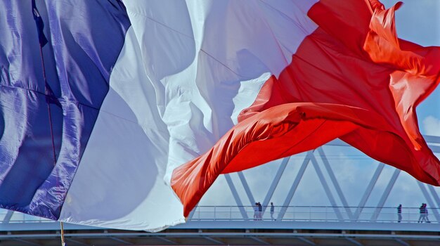 Il agite le drapeau français contre le ciel bleu.