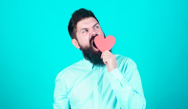 Il déteste la Saint-Valentin Saint Valentin ennuyeux Hipster bâillant avec un petit coeur Homme endormi de la Saint-Valentin avec une carte en forme de coeur Homme barbu tenant un coeur rouge Exprimant son amour