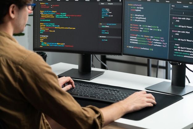 Il développeur travaillant en ligne développement de logiciels codage sur les écrans PC gusher