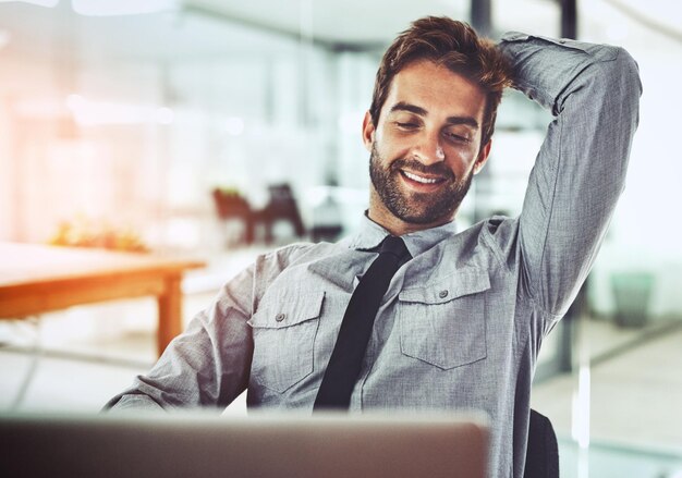 Il écrase ces délais Photo d'un beau jeune homme d'affaires prenant une pause à son bureau dans un bureau